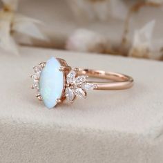 an opalite and diamond ring sitting on top of a white box with flowers