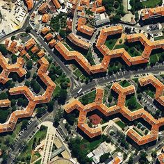 an aerial view of some orange buildings in the middle of a street and parking lot