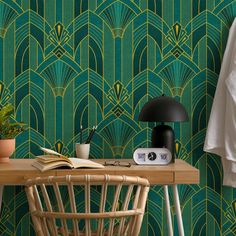 a table with a lamp, book and plant on it in front of a green wallpaper