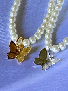 The necklace is made out of 4mm round glass pearls. The necklaces are accented with either gold or silver butterfly charms. Cute Necklace, Butterfly Charm, Freshwater Pearl Necklaces, Colorful Butterflies, Chain Styles, How To Make Beads, Gold Chains, Silver Gold, Freshwater Pearls