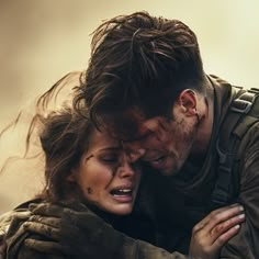 a man and woman hugging each other while they are in the middle of an action scene