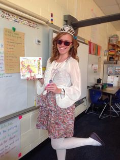 a woman is standing in front of a whiteboard wearing a tiara and sunglasses