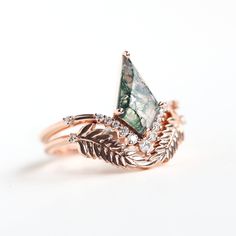 a close up of a ring with an arrow on the front and leaves on the back