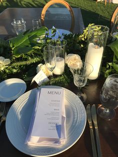 the table is set with place settings, silverware and menus for an event