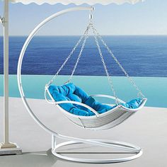 a white hanging chair with blue cushions