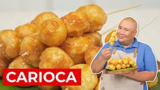 a man holding a plate full of donuts next to a pile of skewers