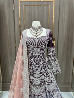 Indulge in luxury with our English Violet Purple Empress Lacha Collection. This exquisite peplum-style lacha features stunning silver work and a blush net dupta. Drape yourself in elegance and sophistication with this one-of-a-kind piece. Elevate your wardrobe with the artful fusion of English and Indian styles. Fabric: Velvet & Organza! WASH CARE INSTRUCTIONS - Please Dry clean only when it is applicable. Ready to Ship! Elegant Pink Net Lehenga, Elegant Net Choli With Traditional Drape, Elegant Semi-stitched Silver Dress, Elegant Net Choli With Zari Work, Elegant Net Salwar Kameez For Reception, Elegant Silver Gown With Resham Embroidery, Elegant Silver Anarkali Set For Reception, Elegant Silver Sharara With Intricate Embroidery, Elegant Silver Sharara With Resham Embroidery