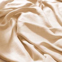 an unmade bed with white sheets and pillows