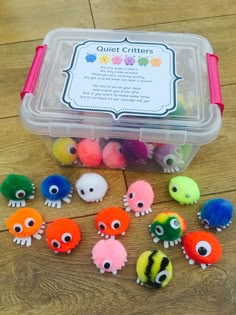 an open plastic container filled with lots of small toy animals sitting on top of a wooden floor