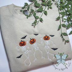 Unleash your inner Halloween spirit with this unique Pumpkin Head Dancing Skeletons Embroidered Sweatshirt. From the inviting feel of the fabric to the intricate embroidery, this garment will put you in the perfect mood for a spooky season. Dare to be bold and enjoy the fright with style! This crewneck is unisex. This is a physical product. Crewneck is embroidered. Embroidered Halloween Sweatshirt, Cricut Sweaters, Pumpkin Embroidery, Rhinestone Hoodie, Embroidered Apparel, Personalized Jacket, Dancing Skeletons, Pumpkin Sweatshirts, Nurse Hat