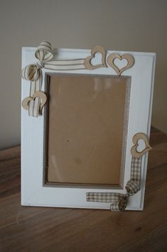 a white frame with hearts on it sitting on a table