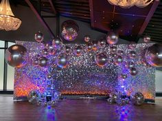 a room with shiny balls and chandeliers hanging from the ceiling in front of it