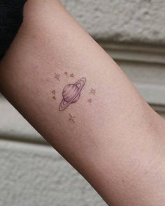 small saturn tattoo on the arm