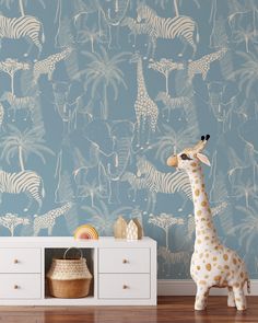 a giraffe standing in front of a blue wallpaper