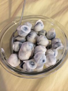 a glass bowl filled with blueberries on top of a table