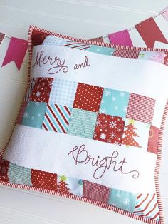 two pillows with merry and bright designs on them sitting next to each other in front of a white wall