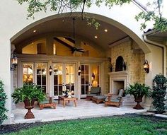 a large house with an arched entrance and lots of greenery on the front lawn