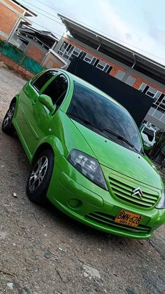 a green car parked in front of a building