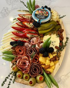 a platter filled with cheese, olives, peppers, and other food items