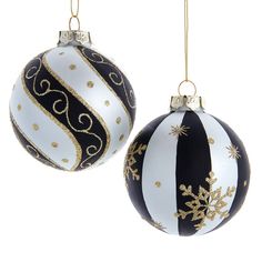 two black and white christmas ornaments hanging from gold strings on a white background with snowflakes