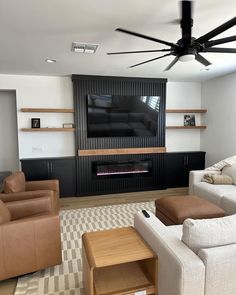 a living room with couches, chairs and a flat screen tv mounted on the wall