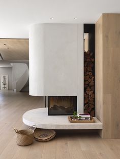 a fireplace in the middle of a living room with wood stacked on it's sides