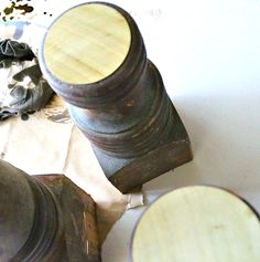 an old wooden object sitting on top of a piece of paper next to other objects