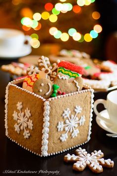 gingerbreads in a box with snowflakes and christmas decorations on the table