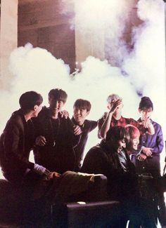 a group of young men standing next to each other in front of a smokestack