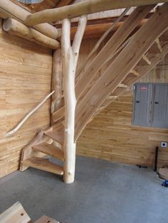 an unfinished room with wooden walls and stairs