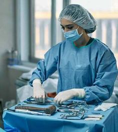 two surgeons in scrubs and masks are performing surgery on an operating table at the hospital