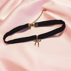 Black bow choker The Bobbie choker is one of three bow charm necklace styles with a short ribbon pendant. We don't use ready-made ribbon but sew a tube of silk so there are no rough edges to rub against your neck. These chokers have a beautiful lustre which only silk can give and we use a silk/spandex mix to give more ease and comfort. These bow chokers come with a gold toned bow charm attached. Your choker comes packaged come packaged in a small pink Mille Saisons' drawstring bag perfect travel Necklace Styles, Bow Choker, Bow Charm, Silk Accessories, Wedding Jewellery Necklace, Style Expert, Black Bow, Wedding Necklace, Drawstring Bag