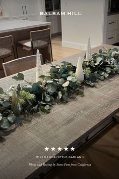 the table is decorated with greenery and cones