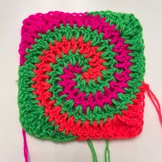 a crocheted square is shown with yarn in the middle and on the side