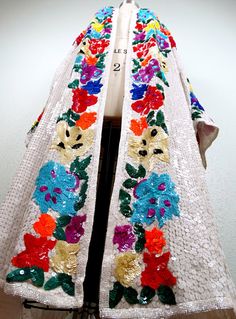 "This is a RARE and GORGEOUS vintage piece by Judith Ann fully embellished with bright white sequins, trimmed with shiny milk-white glass beading and accented with bold sequins in a vibrant floral design. It's in perfect condition! Chest - measures 65\" with all 4 hook-and-eye closures intact Shoulders - measures 32\" hem to hem Arm Circumference - 31\" Length - 44\" from top of the shoulders to the bottom hem All of my items come from a smoke-free and pet-free home. If you have any questions, p Bohemian Wedding Outerwear With Intricate Embroidery, Bohemian Outerwear For Fall Wedding, Embroidered Bohemian Outerwear For Weddings, Bohemian Outerwear With Floral Embroidery For Wedding, Bohemian Embroidered Wedding Outerwear, Spring Bohemian Outerwear With Sequins, Open Kaftan, Sequin Duster, Sequin Kimono