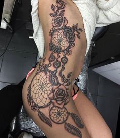 a woman's thigh with an intricate tattoo design on her leg and the bottom part of her thighs