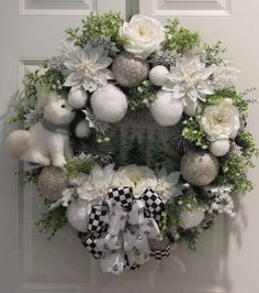 a wreath with white flowers and silver ornaments