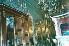 an ornately decorated dining room with chandelier and china cabinet in the center