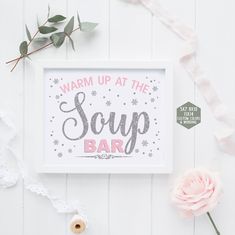 a white framed sign that says warm up at the soap bar next to some flowers