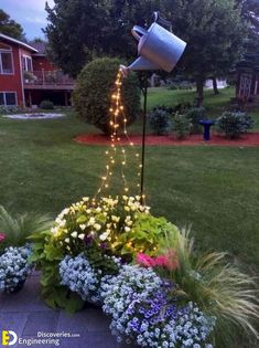 a potted planter filled with flowers and lite up lights in front of a house