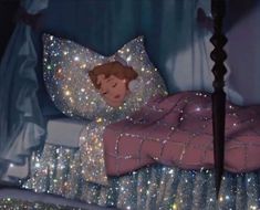 an animated image of a child sleeping on a bed covered in stars and sparkles