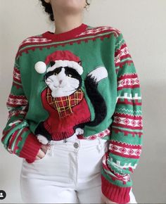 a woman wearing an ugly christmas sweater with a cat on it's chest and hat