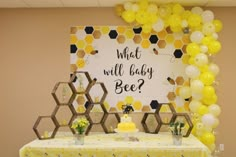 a baby shower with honeycombs and balloons on the wall next to a sign that says, what will baby bee?