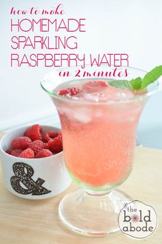 raspberry water in a glass next to a bowl of raspberries