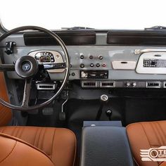 the interior of a car with brown leather seats and dashboards, including steering wheel