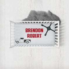 a baby crib with a toy truck in it and the name brendon robert