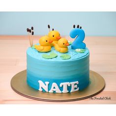 a blue cake with rubber ducks on it