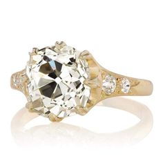 4.20 ct Warm Old Mine Cut Engagement Ring with Side Stones The Cherry 4.20 ring is an AB original design made right here in NYC. The ring centers a GIA-certified 4.20-carat old mine cut diamond of S-T color, VS1 clarity. The stone is set in an 8-prong 18 karat yellow gold setting. Two old mine cut diamonds are bead-set into each shoulder. The side stones combine for approximately 0.30 carats. The ring is currently size 6 and can be resized! Why We Love It One of our all-time favorite settings, w Engagement Ring With Side Stones, Victor Barbone Jewelry, Victor Barbone, Ring With Side Stones, Vintage Inspired Engagement Rings, Diamond Sapphire Engagement Ring, Old Mine Cut Diamond, Engagement Ring Diamond Cut, Antique Engagement