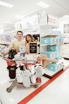 a man and woman are sitting in a shopping cart