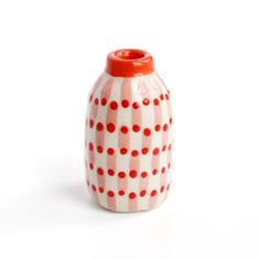 a red and white vase sitting on top of a table